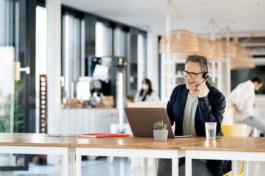 Male customer service representative talking through headset at cafeteria
