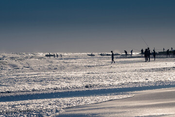 Several beach activities under a silver blue sky
