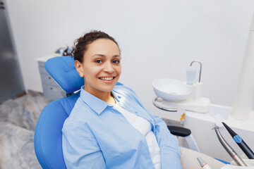 Woman sitting in dental chair and posing at camera