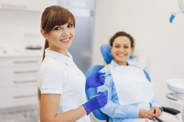 Obraz na płótnie Canvas Dentist posing at camera with dental tools in hands