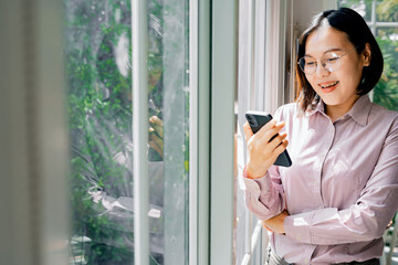 Fototapeta premium Woman working online through mobile phone and notebook computer.