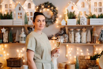 a woman with a glass in the decorated New Year's kitchen. the tradition of decorating the house and cooking for Christmas. a decor shop for the house. traditional recipes.