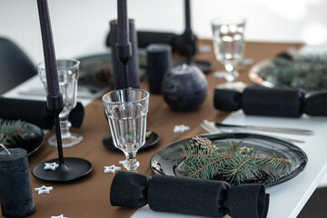 New Year's table with decor. black plate spruce branch