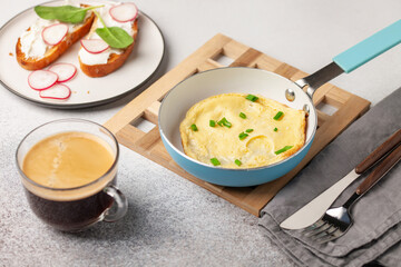 Healthy breakfast - omelette with green onions, toast with cream cheese and vegetables, coffee