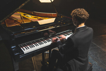 Professional pianist performing a piece on a grand piano.