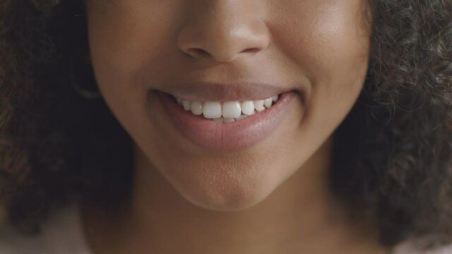Dental care and stomatology concept. Unrecognizable african american woman smiling to camera, showing white smile