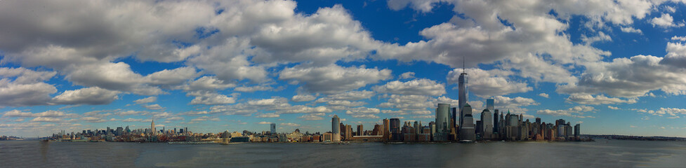 Fototapeta premium Panoramic view of Manhattan with blue sky and white clouds