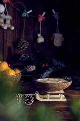 One candle in a coconut shell on the background of a Christmas decor.