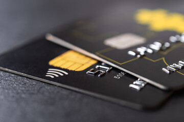 Two black debit cards for cash withdrawals and money transfers. Credit cards with chip and contactless technology macro. Bank charge card for payment for goods and services.