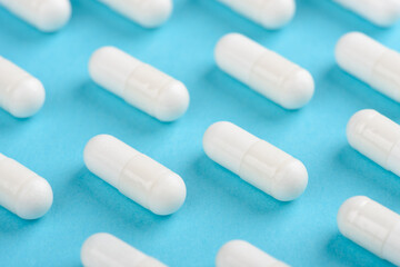 White transparent capsule pill pattern on blue background