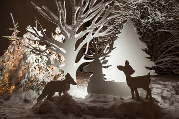 White illuminated animals and trees cut from veneer - Christmas decor at night, Kuldiga, Latvia
