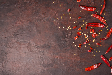 Dried chilies scattered on a dark background top view with copy space