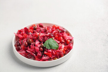 Salad vinaigrette with beets and vegetables on a plate on the table. Healthy diet