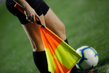 A close up view of a female referee assistant holding a flag during a football match in Sao Paulo, Brazil.