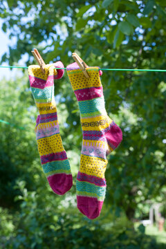 Pair of colorful socks drying on clothesline