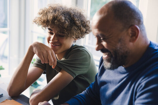 Smiling bald man with son at home