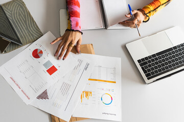 Female student learning finance chart on desk in library