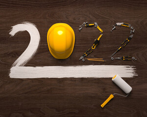 "2022" made from a set of construction tools and a protective helmet on a wooden background. Creative 2022 New Year design template for building and engineering companies. 3D render.