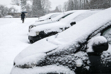 Snowy cars in the parking lot and sidewalk covered In Snow