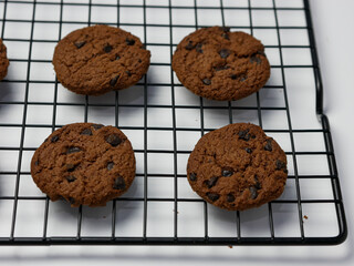 chocolate chip cookies on cooling rack with white background.