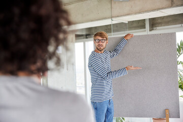 Man wearing eyeglasses holding partition wall at home apartment