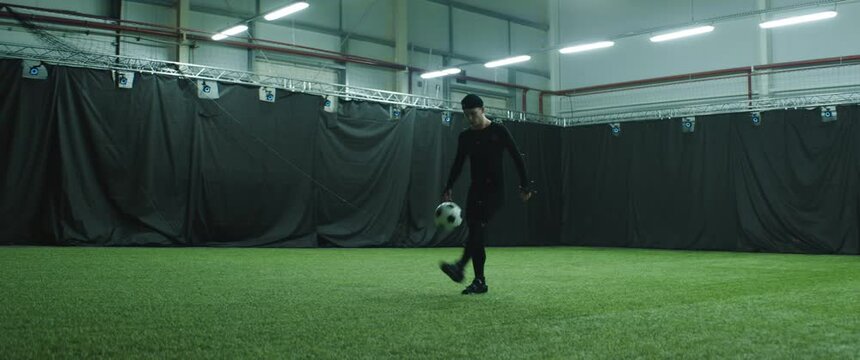 Soccer football player wearing motion capture suit performing tackles as computer game character. Motion capture is an unparalleled method for making animated characters move more realistically