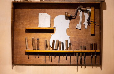 Old wooden board hanging on the wall with a set of different tools for handmade woodwork