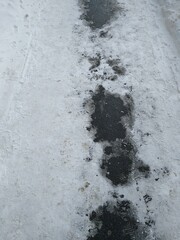 Asphalt path with melted snow close-up. High quality photo