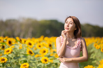 Asian woman at sunflower field portrait outdoor.