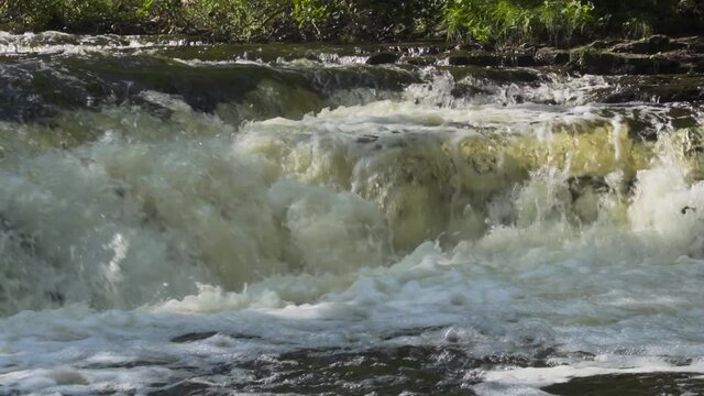 River water flowing over the rocks; Ocqueoc Falls, rushing water over layers of rocks in Northwest Michigan after months of rain in late summer--late morning. 436