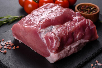 Raw pork steak on a cutting board with herbs and spices