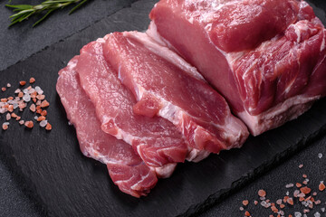 Raw pork steak on a cutting board with herbs and spices