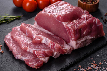 Raw pork steak on a cutting board with herbs and spices