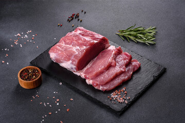 Fototapeta na wymiar Raw pork steak on a cutting board with herbs and spices