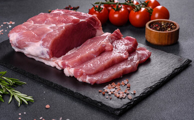 Raw pork steak on a cutting board with herbs and spices