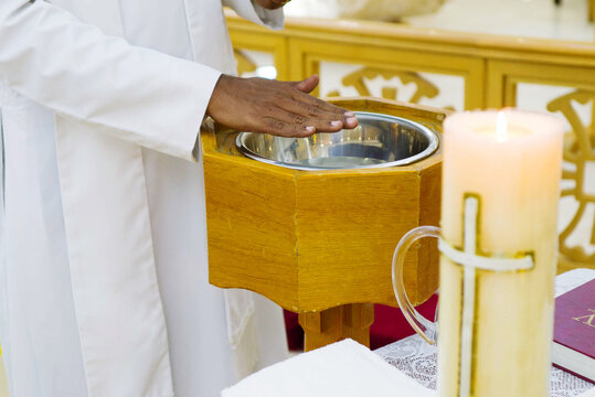 Pastor at the christening ceremony with the hand over baptismal font