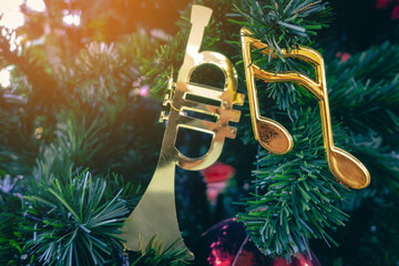 Shiny treble clef ornament or gold music notes hanging on pine tree. Stylish christmas decorations....