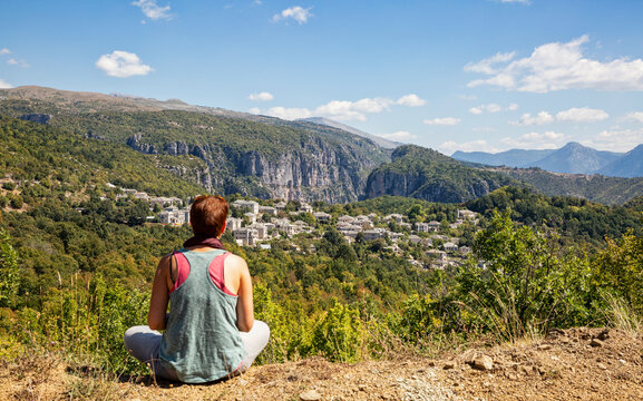 Greece, Epirus, Zagori, Female hiker admiring forest surrounding village inVikos-AoosNational Park during summer