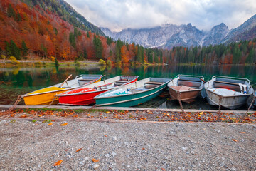 Fototapeta premium Beautiful Fusine lake in nice autumn colors in the background with the Mangart mountains at sunset, near Slovenia