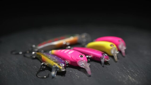 Fishing lures of different colors and shapes for fishing on a brown table. Background in blur.