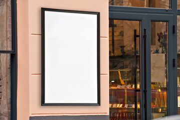 Rectangular sign on the building. Copy space and space for text. Mockup for design. Blank template for advertising. White frame on a glass case. Advertising on the window of a restaurant or shop.