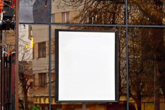 Rectangular Sign On The Building. Copy Space And Space For Text. Mockup For Design. Blank Template For Advertising. White Frame On A Glass Case. Advertising On The Window Of A Restaurant Or Shop.