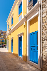 Fototapeta na wymiar Greek house with blue door and window on Symi island in Greece