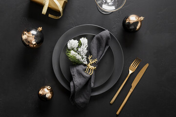 New Year and Christmas table setting with black plates, gold deer ring, gift and gold cutlery....
