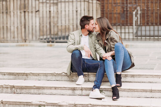 Couple kissing each other while sitting on steps