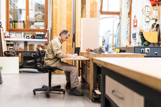 Male craftsperson working at table in workshop