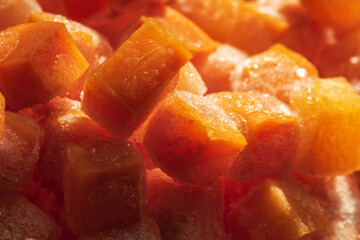 Frozen fresh carrot cube pieces closeup background