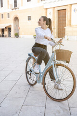 Full body portrait of a beautiful young woman casual dressed with retro bicycle outdoors