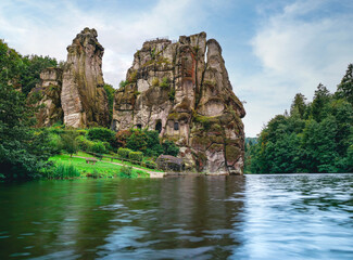 Fototapeta na wymiar Externsteine in the Teutoburg Forest in Germany. Travel and sights of city breaks. landmarks, travel guide Europe. Banner or panoramic postcard