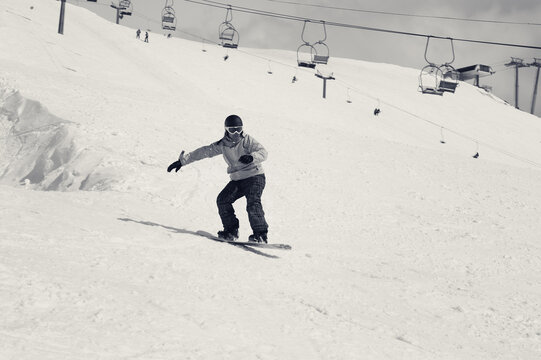 Snowboarder jumping on snowy ski slope. Black and white retro toned image.